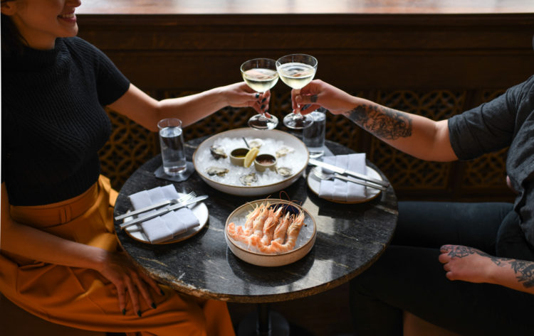 Two People Dining With Drinks And Seafood.